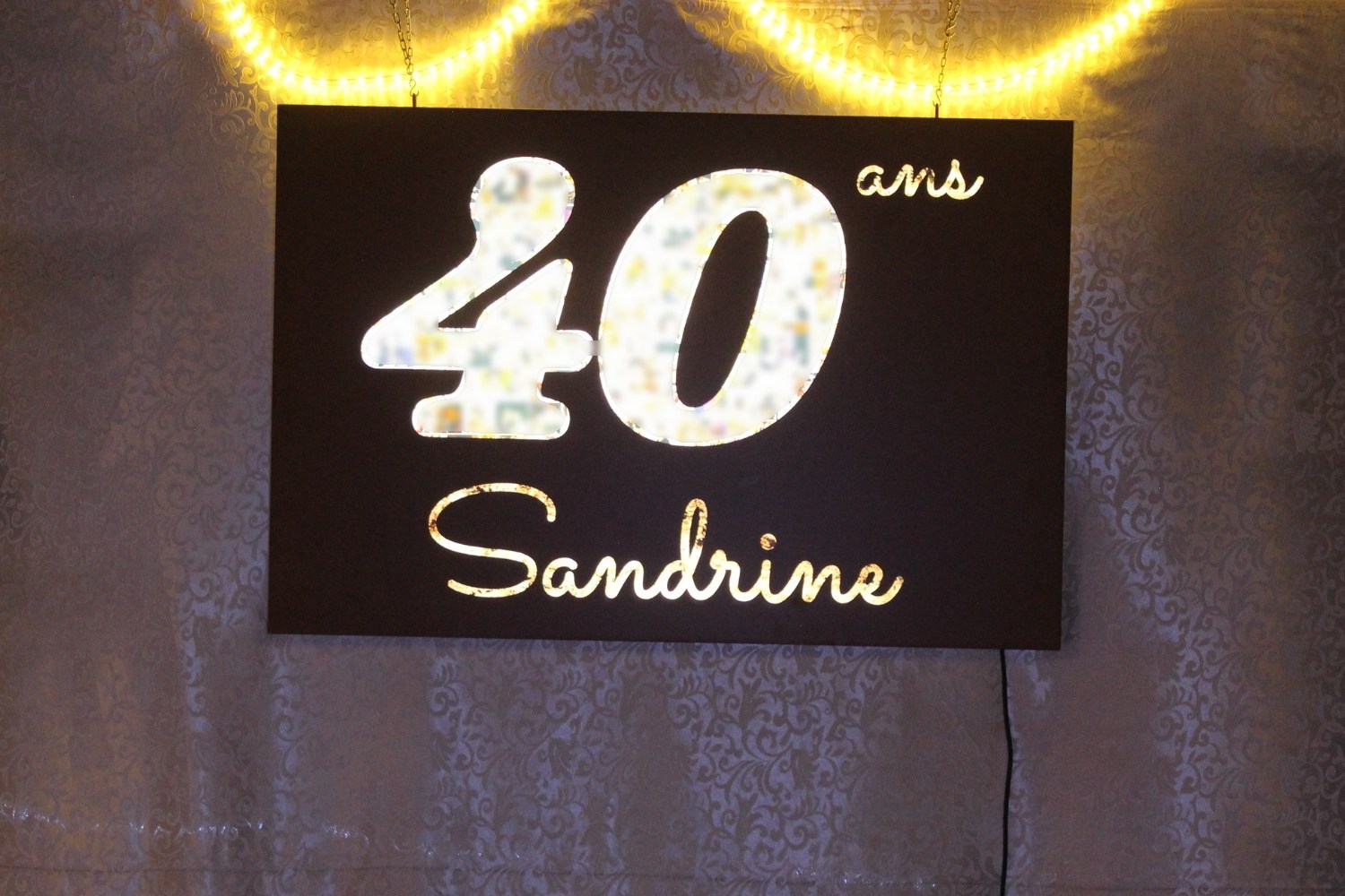 Caisson anniversaire 40 ans à Cuers : Caisson lumineux, le 40 rempli de photos (visages floutés)