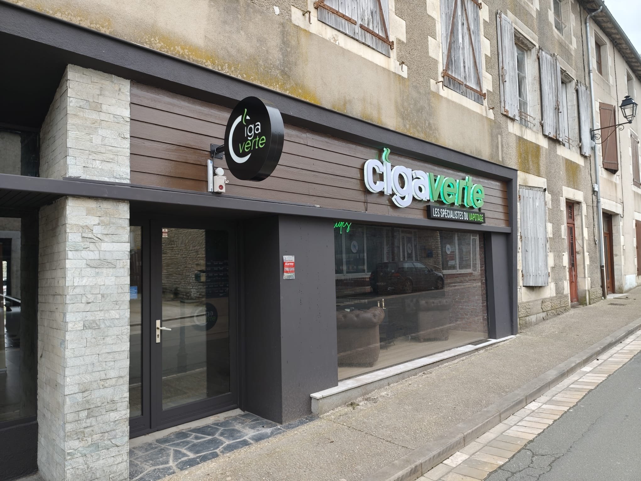 Ciga Verte à Couhé : Façade avec enseigne ronde en drapeau et lettres lumineuses