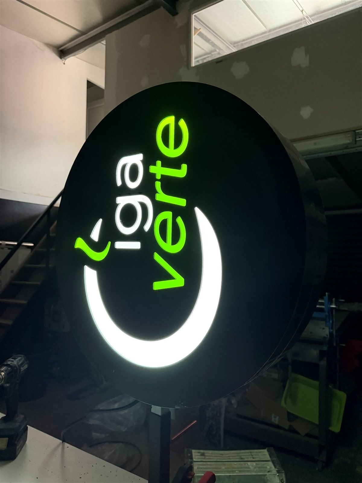 Enseigne drapeau ronde lumineuse Ciga Verte allumée à l'atelier