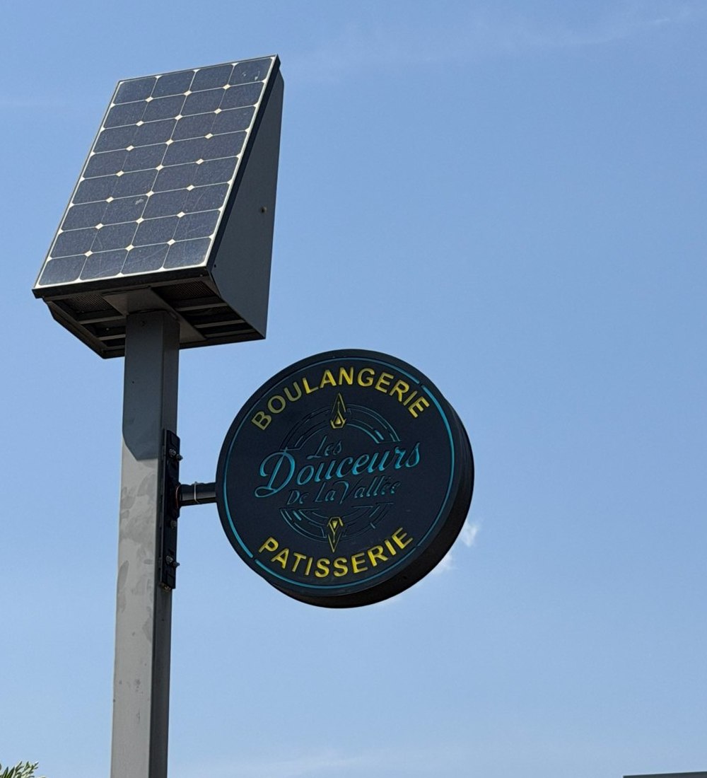 Enseigne drapeau ronde sur mât solaire Les Douceurs de la Vallée à Solliès-Toucas, de jour