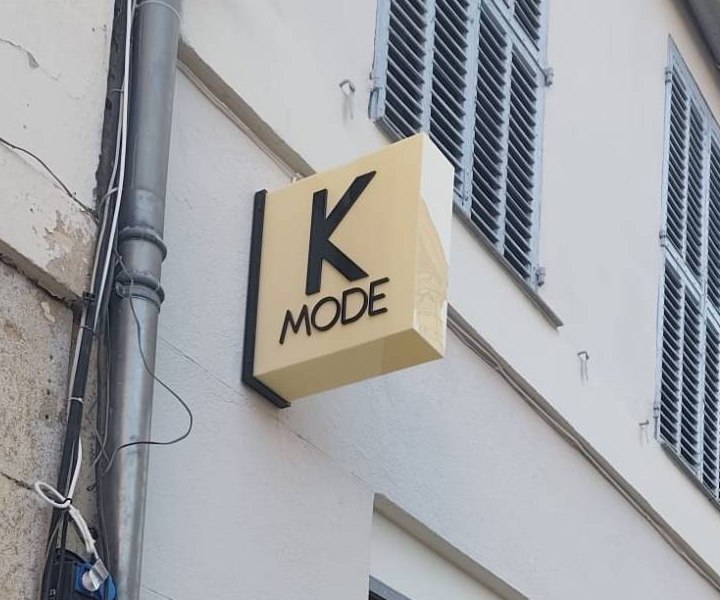 Enseigne drapeau lumineuse carrée de la boutique K Mode dans le centre d'Hyères
