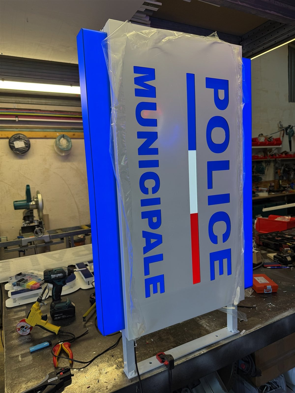Enseigne drapeau Police municipale en fabrication à l'atelier, encore protégée
