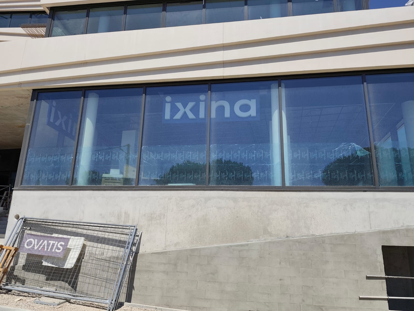 Ixina à La Seyne-sur-Mer : Panneaux bleus à lettres en relief derrière les baies vitrées