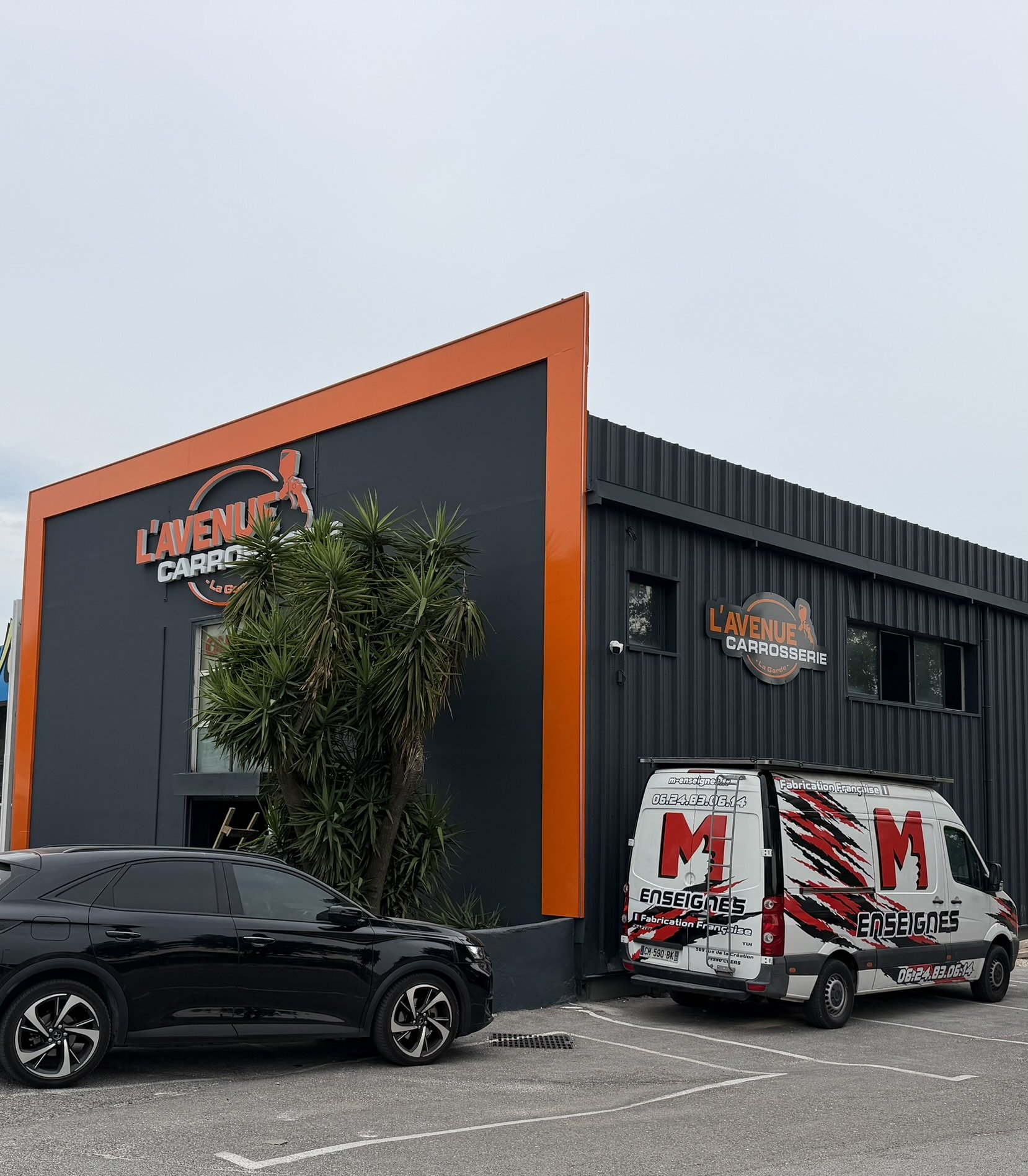 L'Avenue Carrosserie à La Garde vue de biais, cadre orange et panneau découpé sur le côté