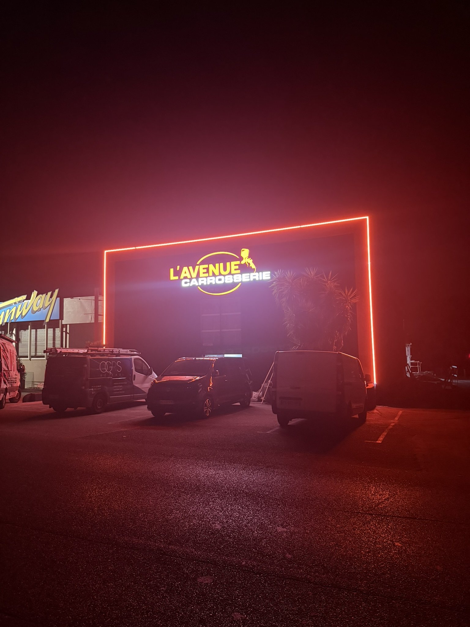 L'Avenue Carrosserie à La Garde vue de loin la nuit, le contour en néon LED se détache dans le noir