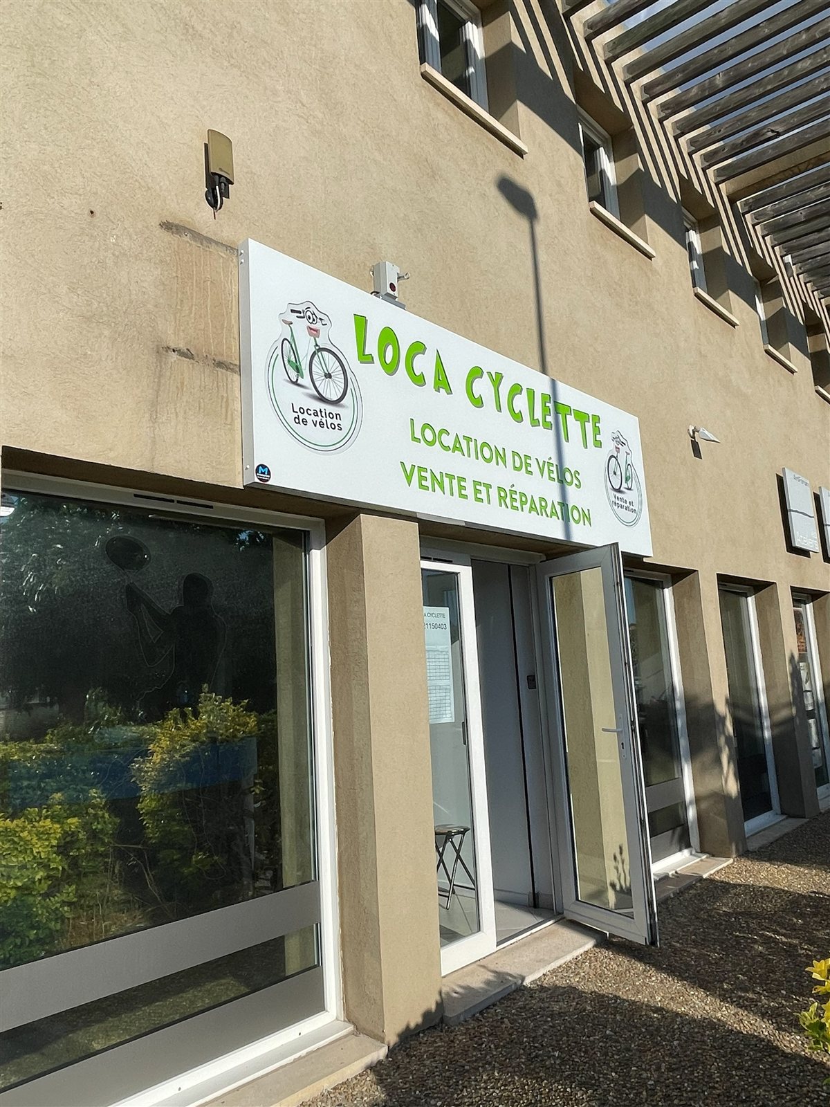Enseigne Loca Cyclette, location de vélos, vente et réparation, posée au-dessus de l'entrée à Carqueiranne