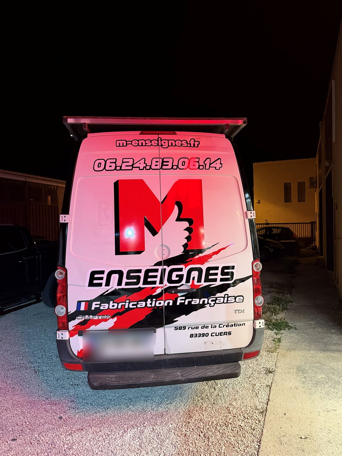 Arrière du fourgon M Enseignes de nuit : grand M, site internet, téléphone et Fabrication française