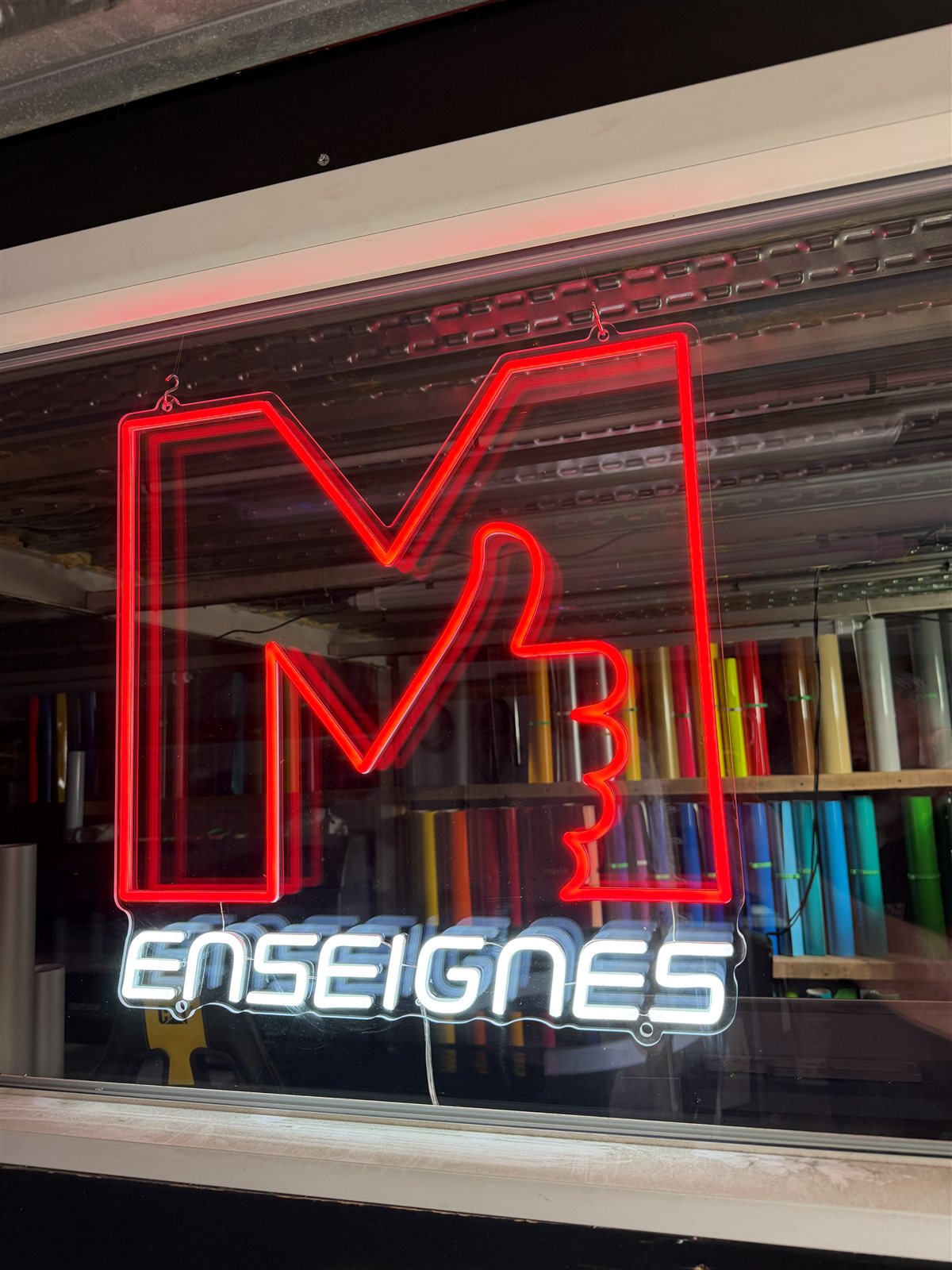 M Enseignes, néon à Cuers : Logo en néon LED derrière la vitrine de l'atelier