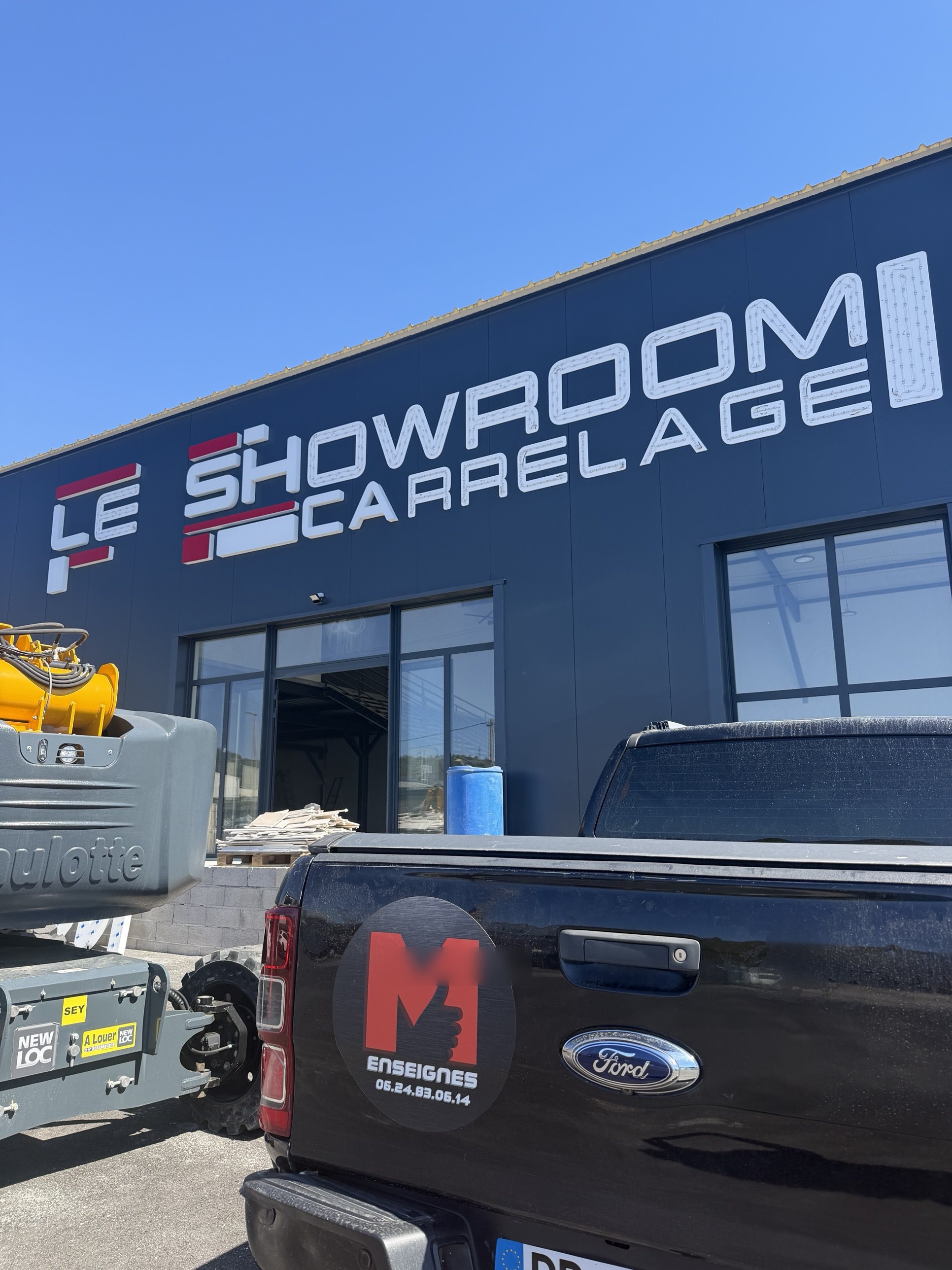 Lettres en cours de pose sur la façade du Showroom Carrelage à La Farlède, pick-up M Enseignes devant