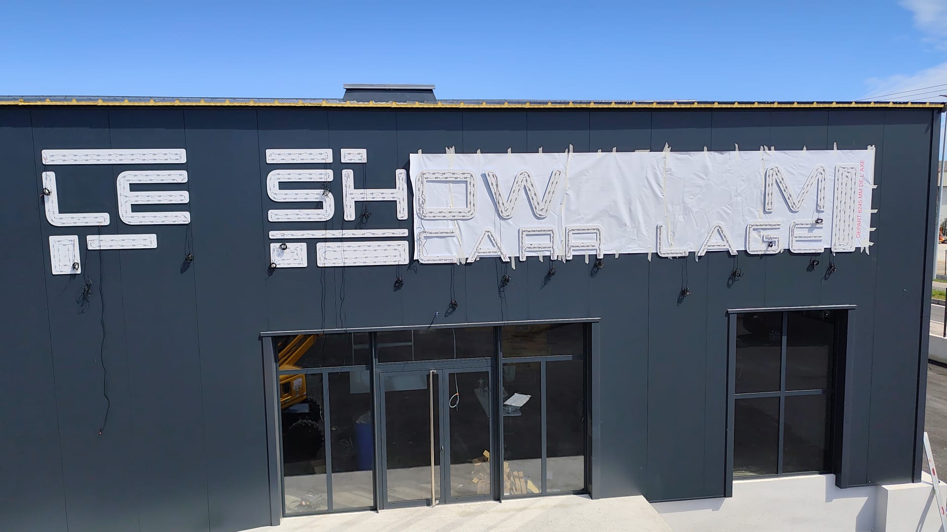 Gabarit papier à l'échelle 1 scotché sur la façade et premières semelles PVC posées, sur le Showroom Carrelage à La Farlède