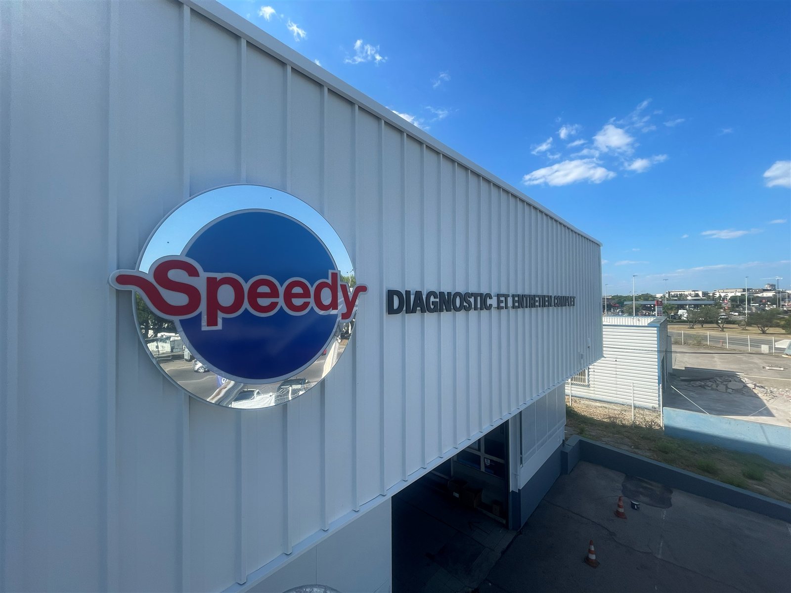 Logo rond Speedy et lettres découpées Diagnostic et entretien complet sur un bardage blanc à Montpellier