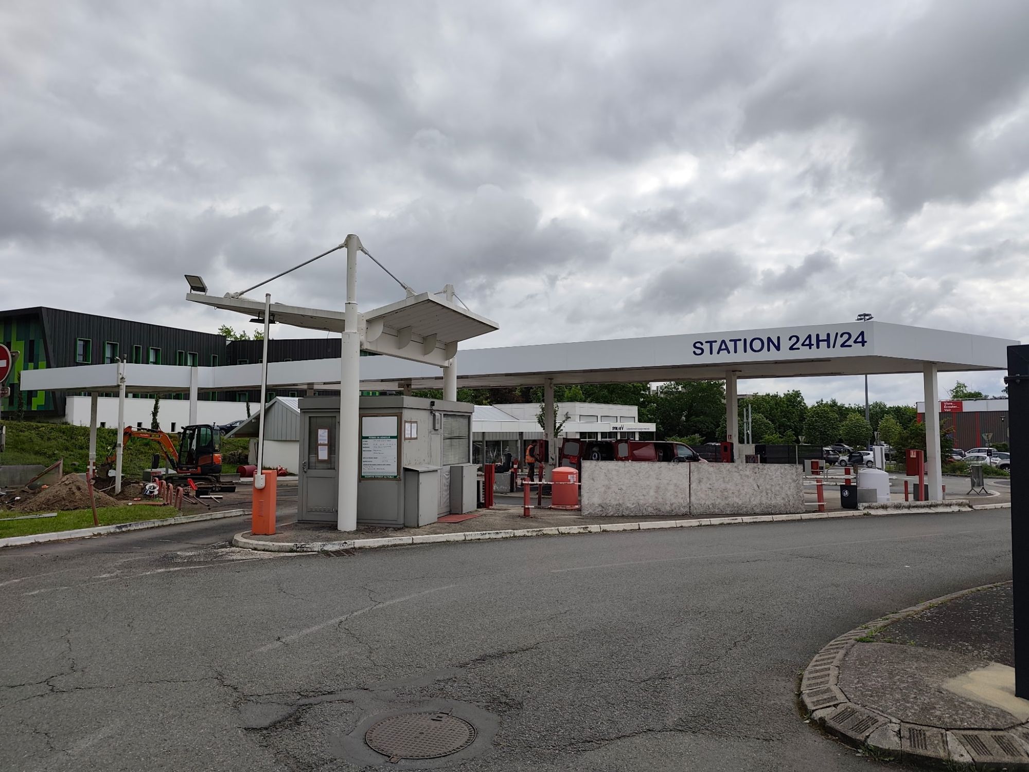 Entrée de la station-service d'Aurillac, avec la cabine et l'auvent Station 24h/24 au fond