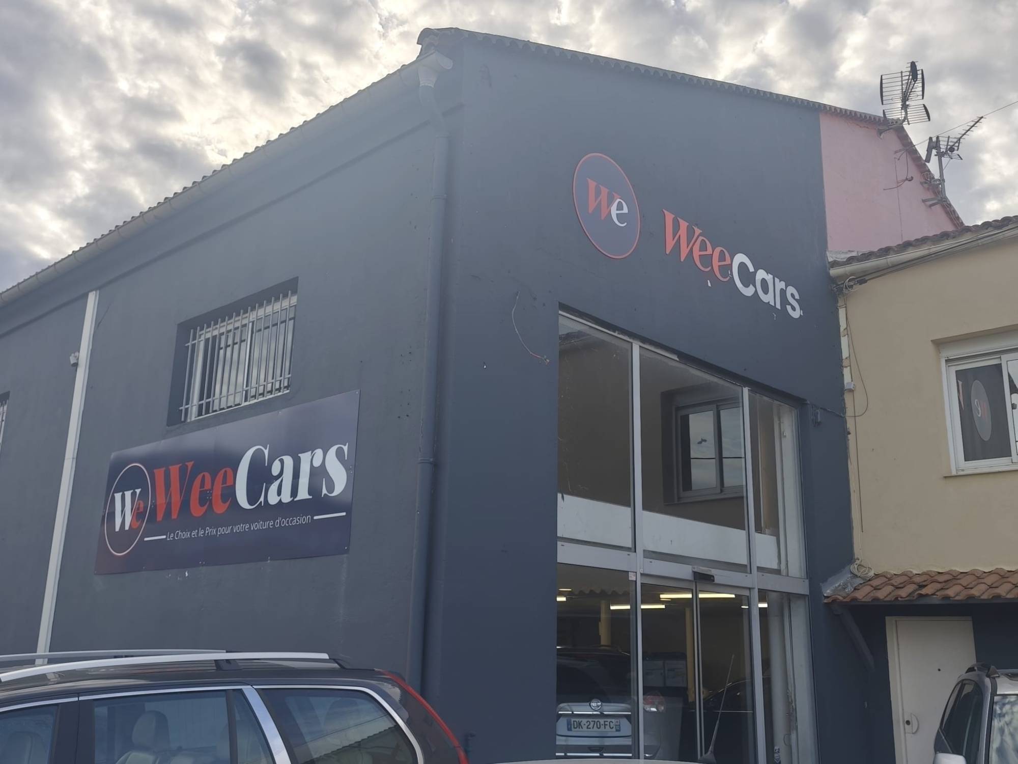 WeeCars à Hyères : Logo rond, lettrage et panneau sur la façade